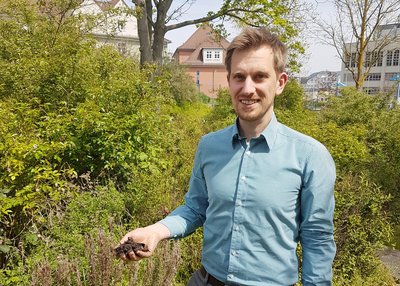 Projektleiter Prof. Dr. Christoph Koch mit Bodenprobe auf dem Campus der Ernst-Abbe-Hochschule Jena