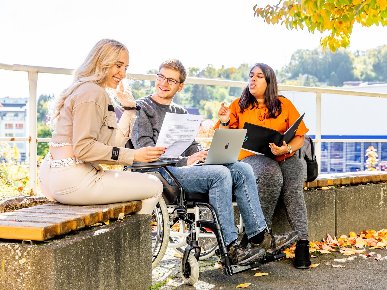 Studierende sitzen auf dem Campus und lernen