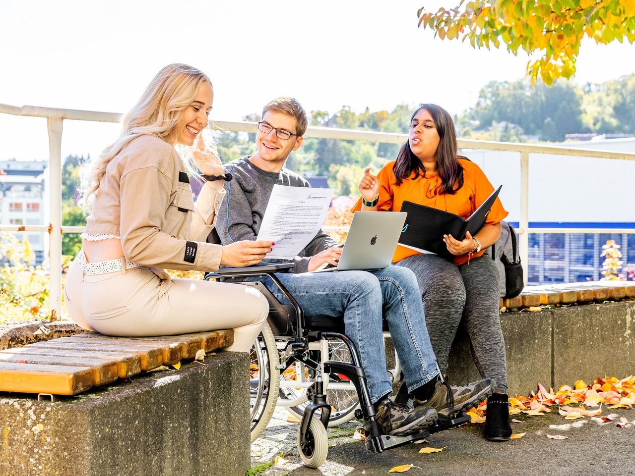 Studierende sitzen auf dem Campus und lernen