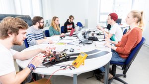Studierende arbeiten an einem Elektronikprojekt mit Miniaturfahrzeug – Lehrsituation im Studienschwerpunkt Technik an der Ernst-Abbe-Hochschule Jena