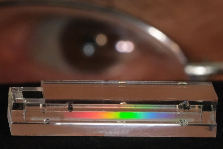 Das Bild zeigt einen spektralen Sensor vor dem Auge des Entwicklers. Diese Sensoren müssen klein, kompakt und einfach konstruiert sein und zerlegen das Licht in seine verschiedenen "Farben".