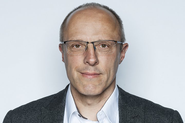 Mann mittleren Alters mit Brille Blickt freundlich in die Kamera