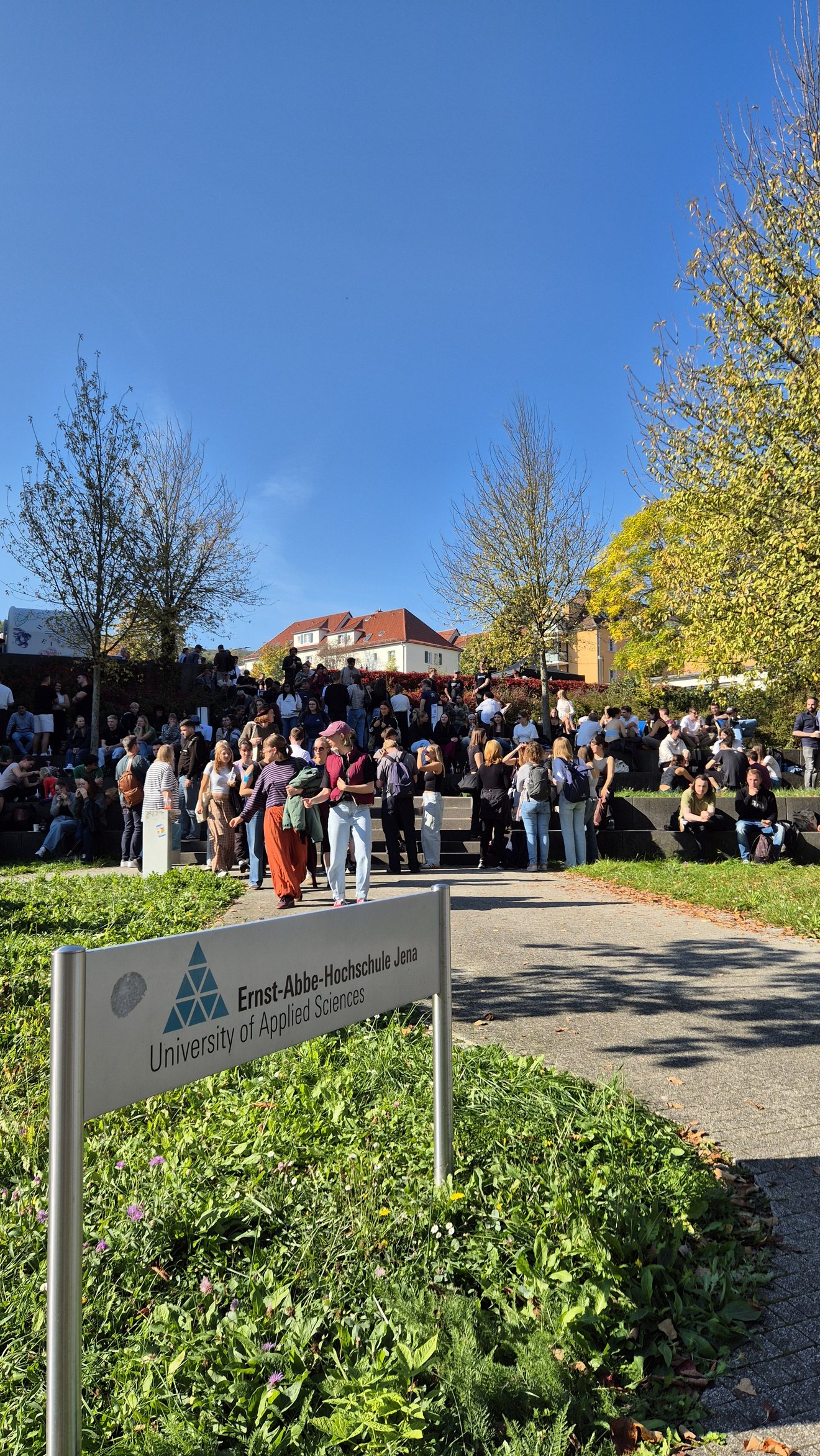 viele junge Menschen erkunden den Hochschulcampus