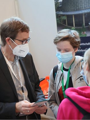 Prof. Voß (ET/IT) mit einer Schülerinnengruppe am Stand der EAH Jena