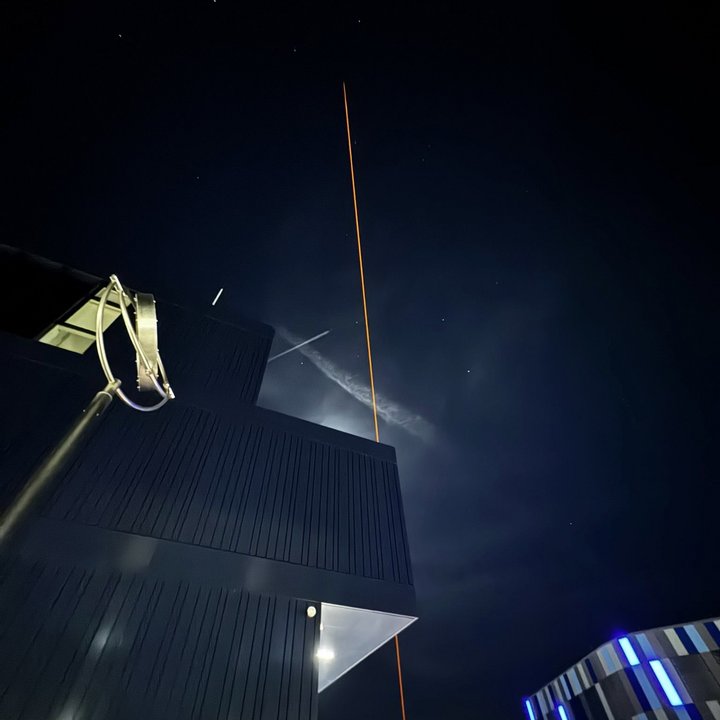 Ein großer Stratosphärenballon steigt mit einer kleinen technischen Nutzlast über dem Campus in die Höhe.
