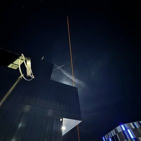 Ein großer Stratosphärenballon steigt mit einer kleinen technischen Nutzlast über dem Campus in die Höhe.