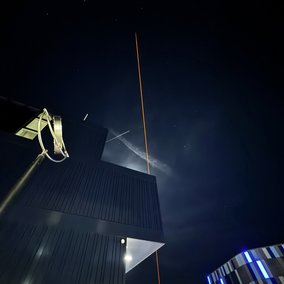 Ein großer Stratosphärenballon steigt mit einer kleinen technischen Nutzlast über dem Campus in die Höhe.