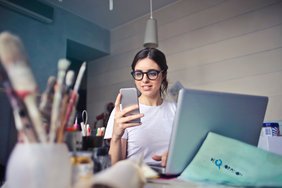 Junge Frau mit Notebook und Handy