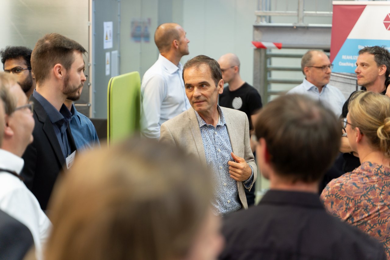 Personen im Gespräch während der Führung durch das StartUpLab