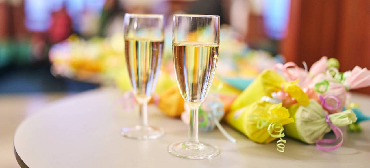 Veranstaltungen feiern Zwei Gläser Sekt stehen auf einem Tisch. Daneben liegen kleine Zuckertüten.