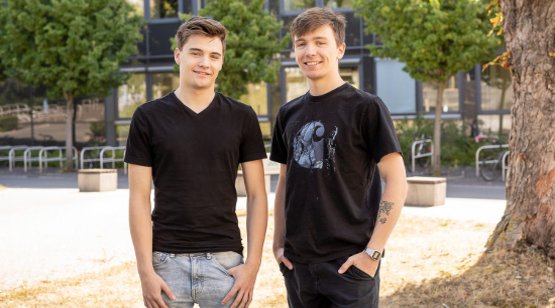 zwei junge Männer stehen auf dem Campus