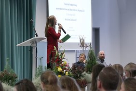 Moderatorin und Hochschulensemble