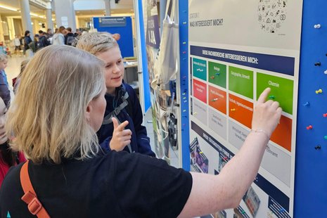 Orientierungsparcour auf dem MINT-Festival Schüler vor Pinntafel