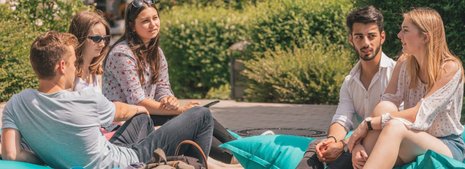 Studierende auf dem sommerlichen Campus