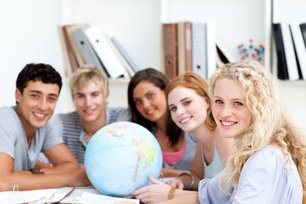 Foto internationale Studierende sitzen um einen Globus