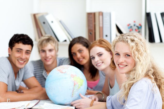 Foto internationale Studierende sitzen um einen Globus