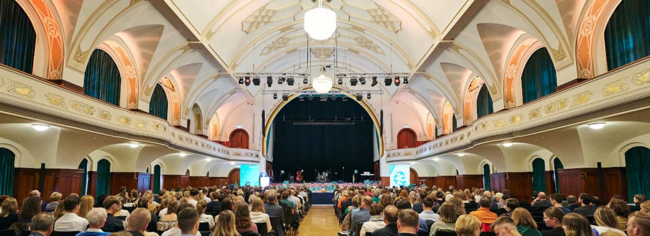 Blick in einen festlichen Saal mit vielem Publikum.