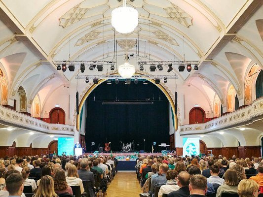 Blick in einen festlichen Saal mit vielem Publikum.