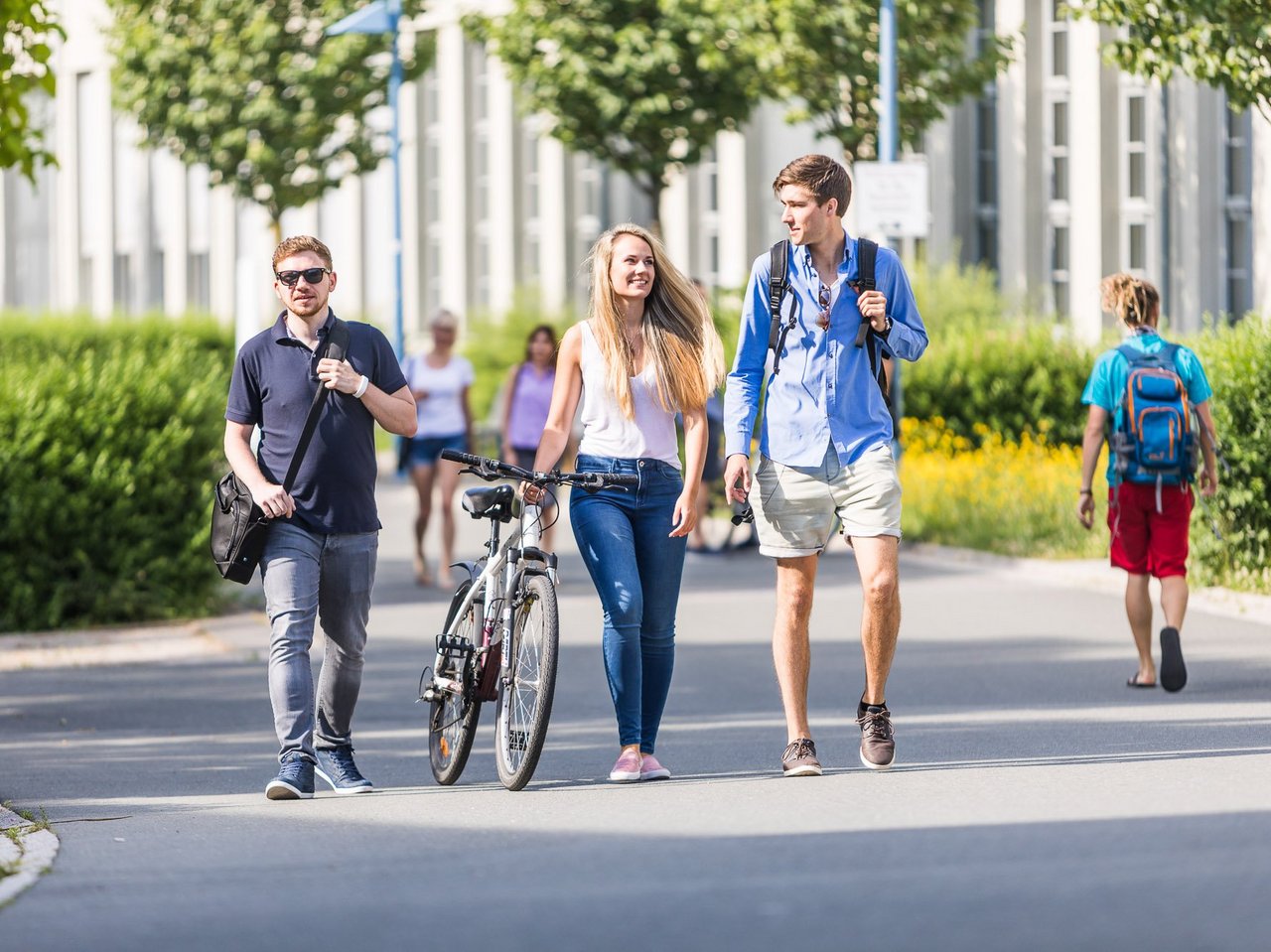 Zu sehen sind Studierende, welche über den Campus laufen