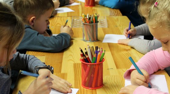 Kinder malen an einem Tisch