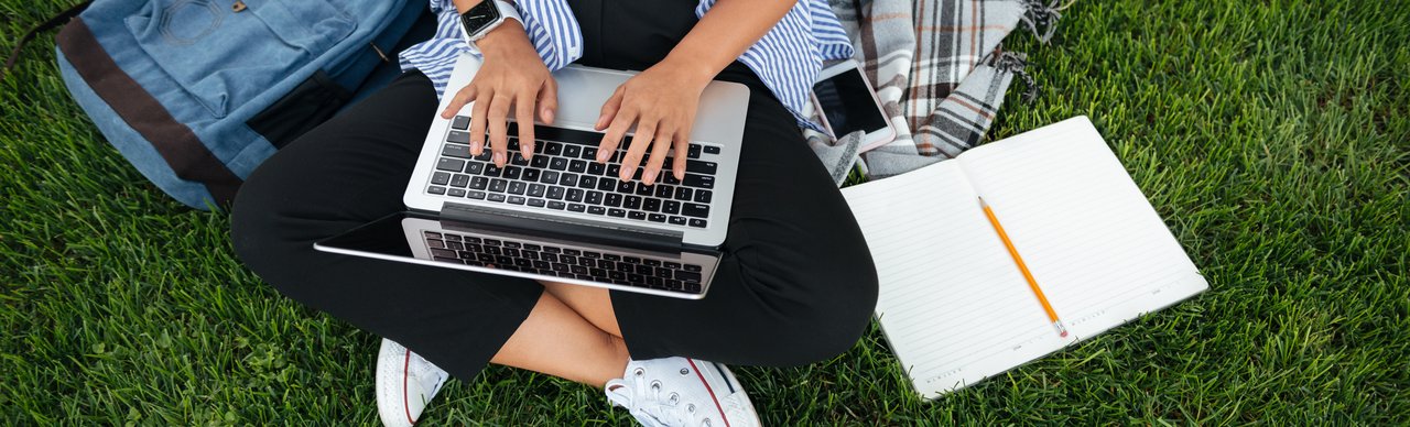 Studierende am Laptop auf einer Wiese