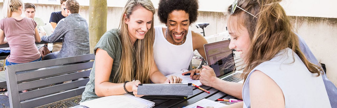 Studierende bei der Arbeit auf dem Campusgelände 