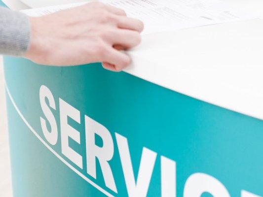 Eine Person steht an einem Servicetresen