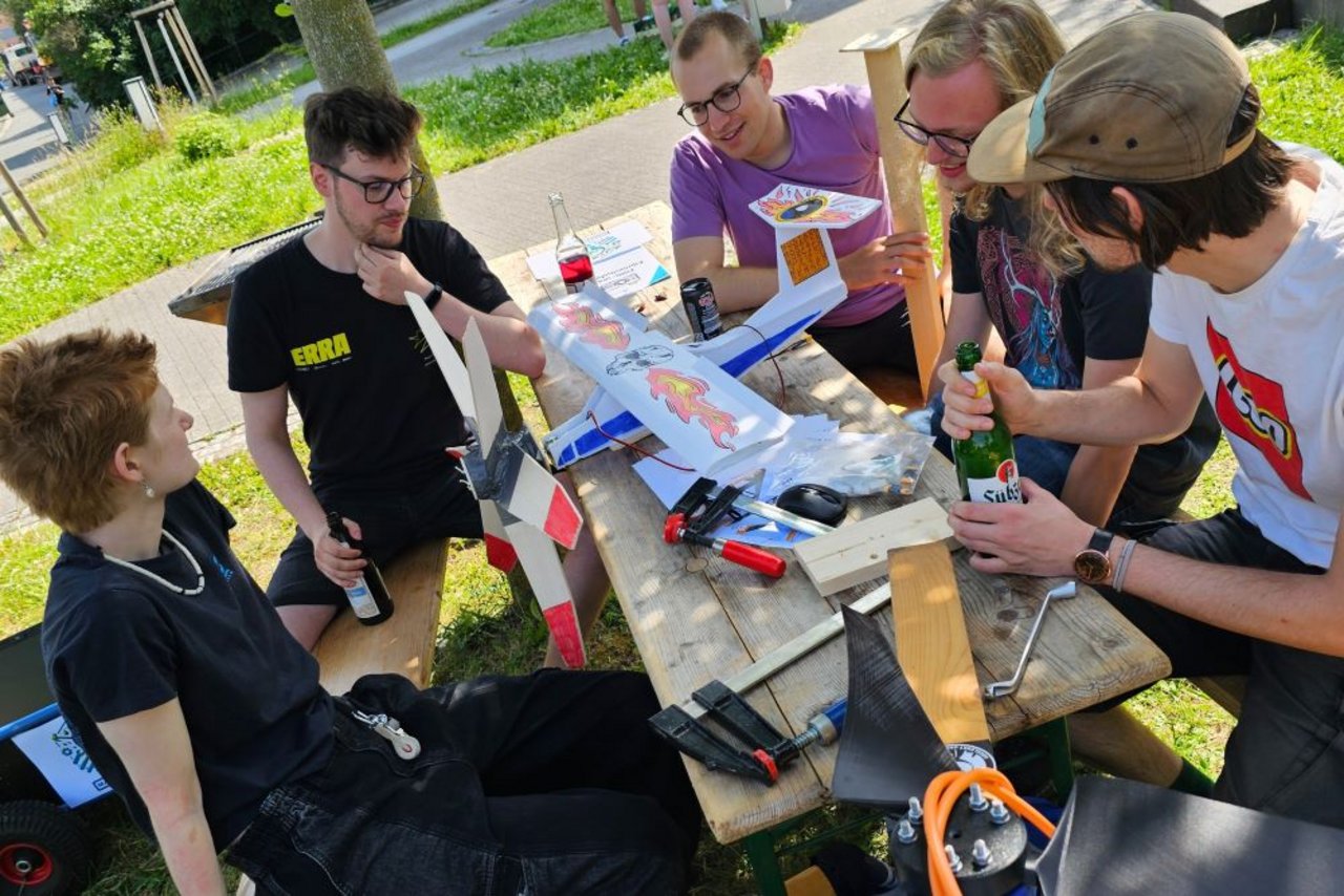 Zusammen sitzen am Tisch und über das Projekt Windenergie diskutieren