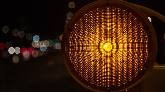 Barrierefreie visuelle Kontraste und Beleuchtung Gelbe Warnleuchte vor dunklem Hintergrund